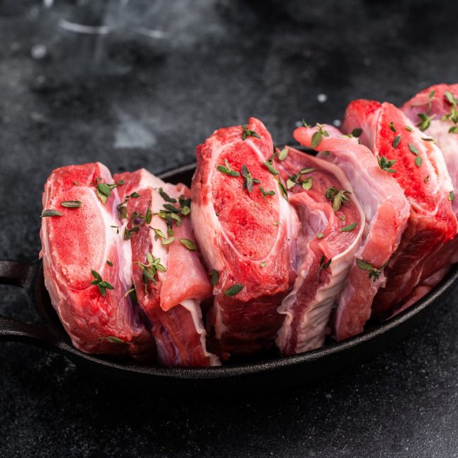 Raw Veal Short Ribs, fresh meat with thyme. black background. top view.